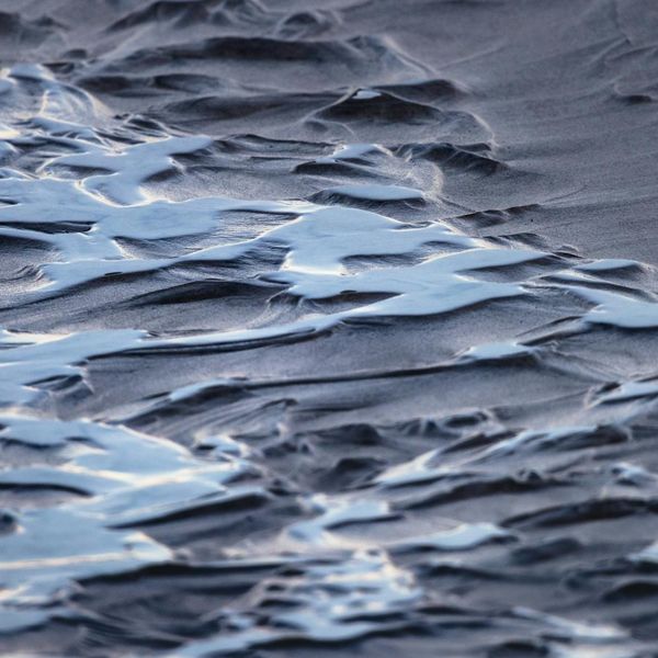 Abstract image of gentle waves on a sandy beach.